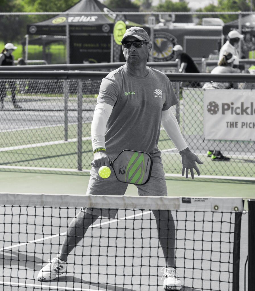 Pickleball player hitting ball