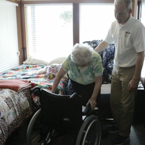 women getting into wheel chair in residential environment