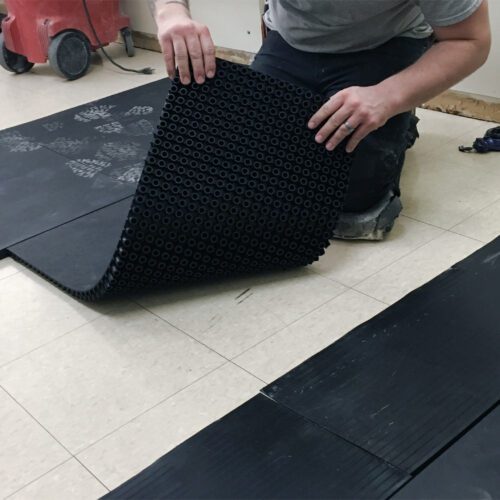 SmartCells tiles being installed as an underlayment in a medical facility