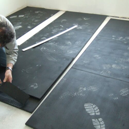SmartCells tiles being installed as an underlayment in a medical facility