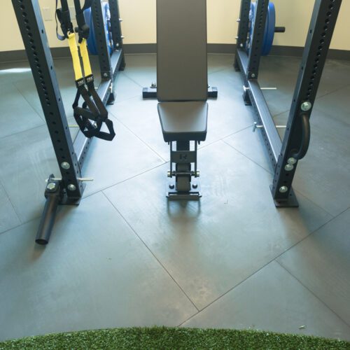 Weightlifting equipment sitting on top of SmartCells physical therapy flooring