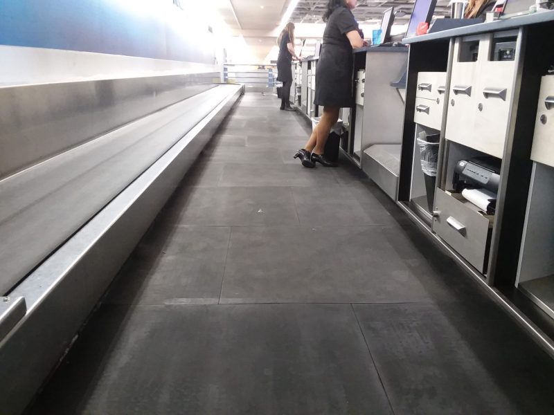 Airline employee standing on SmartCells custom flooring install in airport