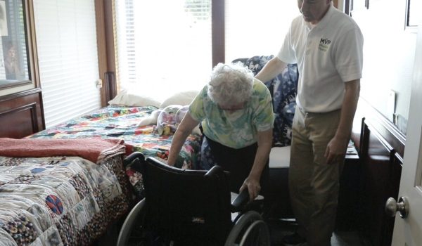 women getting into wheel chair in residential environment