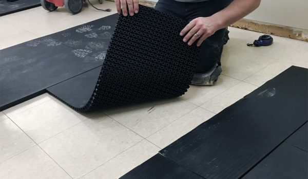 SmartCells tiles being installed as an underlayment in a medical facility