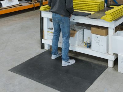 Employee standing on SmartCells 3x5 black anti-fatigue mat