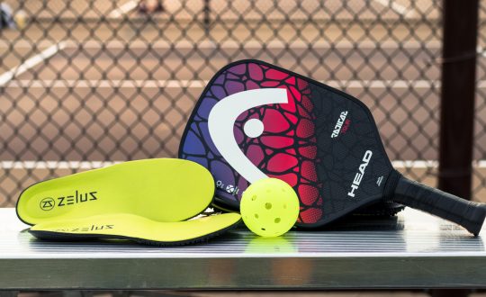 Zelus Insoles sitting next to pickleball paddle and ball